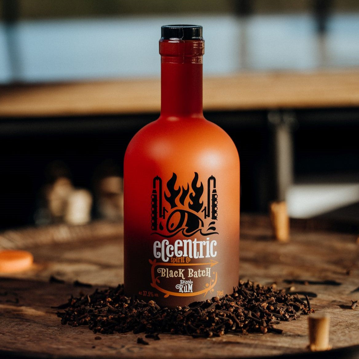 A bottle of In the Welsh Wind Welsh spiced rum on a barrel